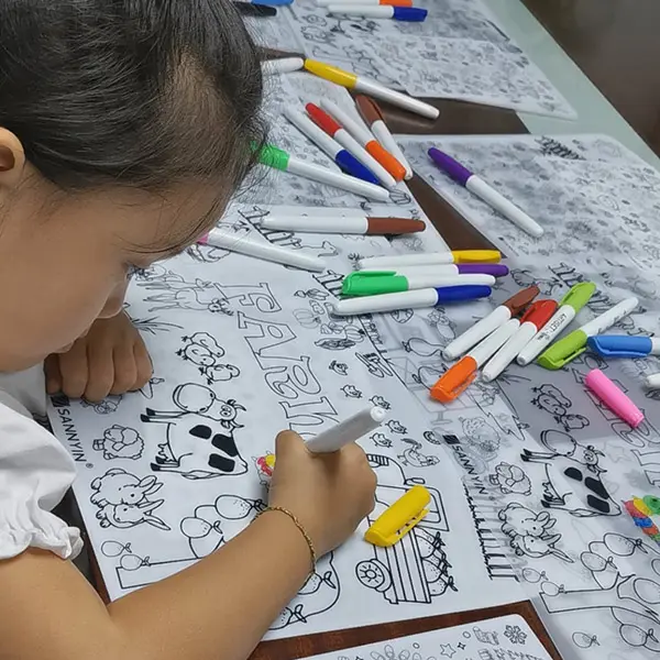 طفل يرسم على حصيرة التلوين
